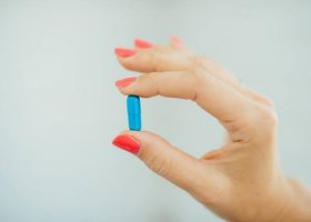 Hand Holding a Blue Capsule